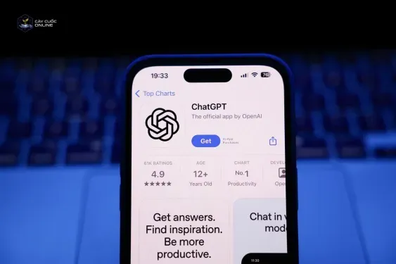 A laptop keyboard and ChatGPT on App Store displayed on a phone screen.