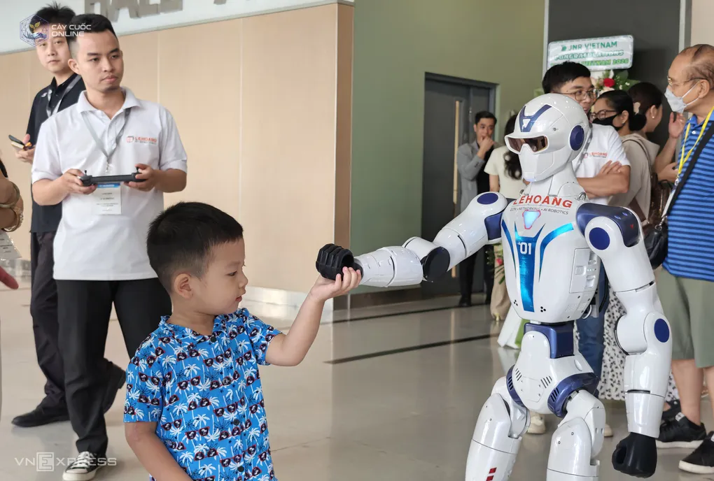Robot hình người tương tác với một khách nhí tại một sự kiện công nghệ ở TP HCM. Ảnh: Bảo Lâm